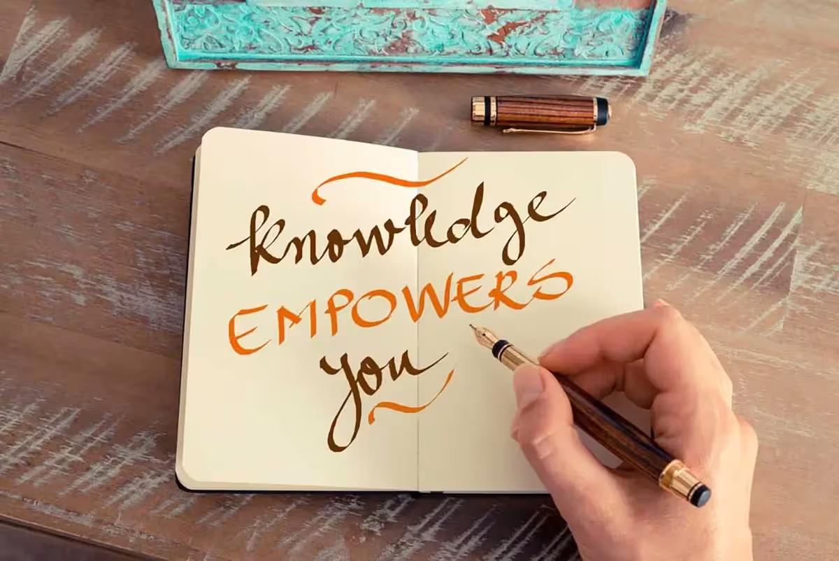 The Qnet Commitment 2 knowledge empowers you text written on a notebook