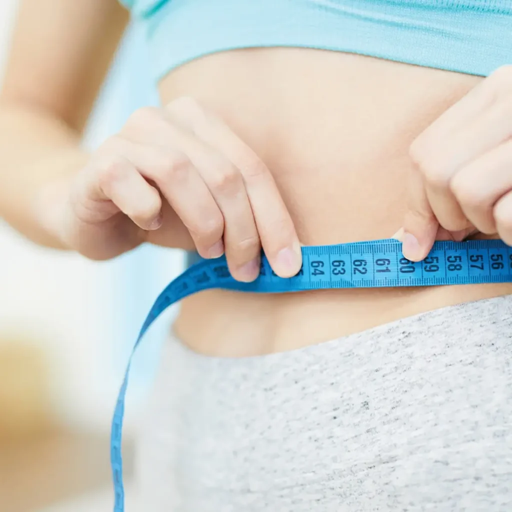 Four Healthy Habits For A Slimmer You 4 Woman measuring her waist with blue measuring tape
