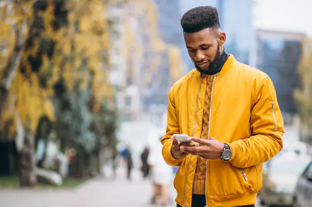 african-american-student-walking-street-talking-phone