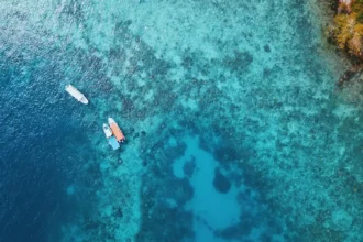 A stunning aerial perspective of a serene lagoon, featuring small fishing boats gracefully adrift on its tranquil surface.