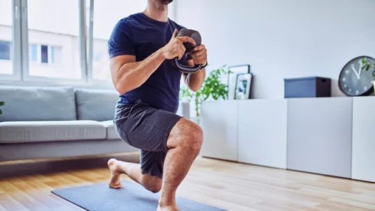 Follow These 4 Healthy Habits Of Successful People To Change Your Life 3 Guy working out with a kettle bell as part of his fitness resolutions to develop the healthy habits of successful people