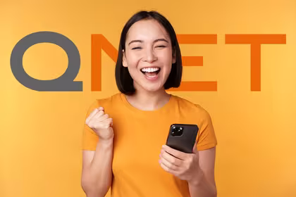 Excited woman holding her phone after a successful QNET Registration