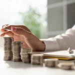 image of hand counting stacks of coins