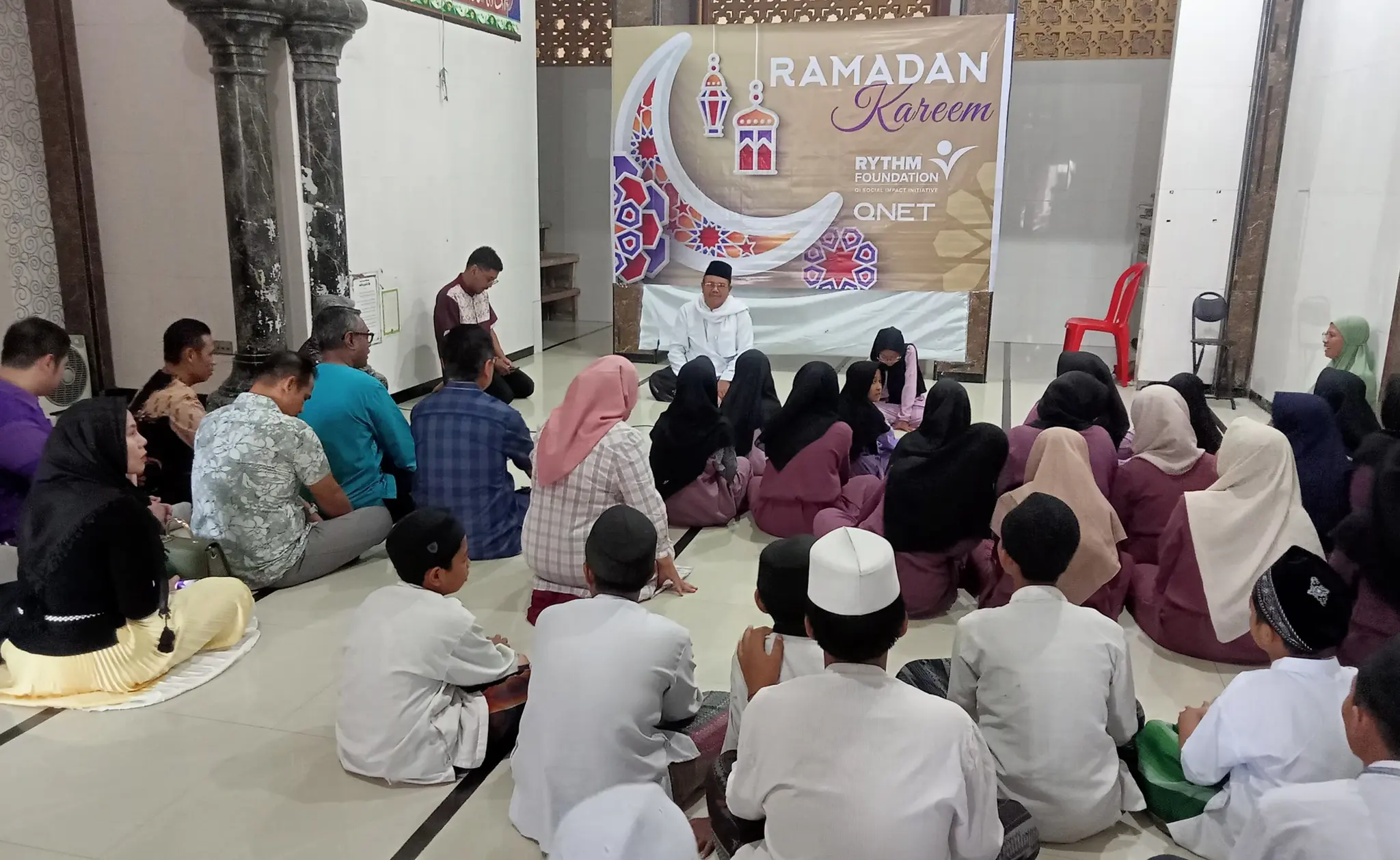 Why Ramadan Is A Special Time For Giving At Qnet 2 People sitting on the floor while reflecting during a QNET Ramadan initiative in Indonesia