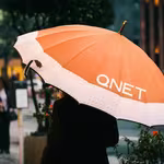 Monsoon Season Tips by QNET - girl with an orange umbrella
