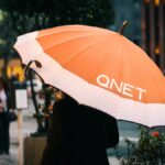 Rainy Season Tips by QNET - girl with an orange umbrella