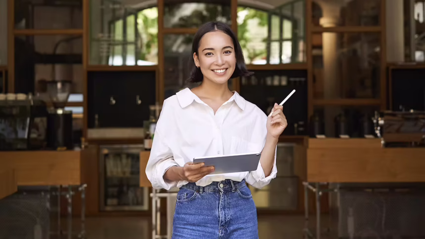 What is Micro-Entrepreneurship? Woman holds up a tablet and pen in front of a nice venue