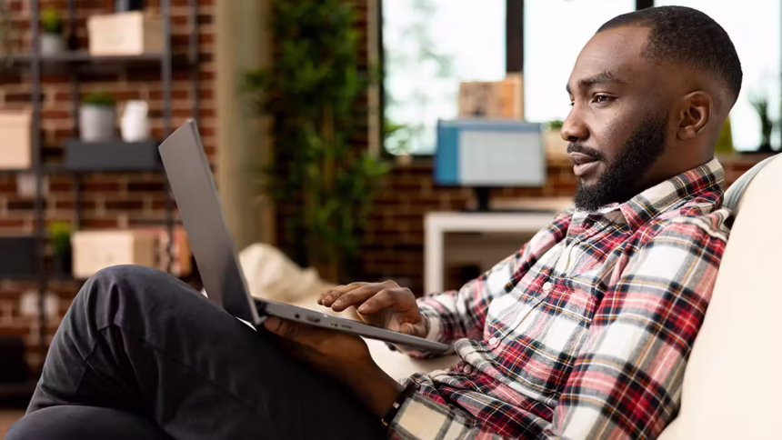 Man looking at laptop | Is QNET a Scam?