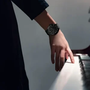 Woman's hand on the piano; there is a Bernhard H. Mayer Alto Ceramic watch on her wrist